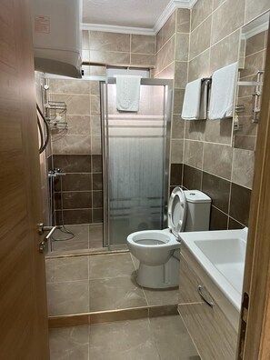 A bathroom with a shower, toilet, and bathtub. - Cirpan Apart Otel (Enez)