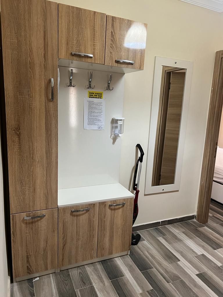 Une pièce comprenant une armoire en bois, un meuble blanc et un miroir.