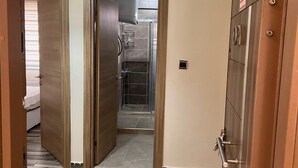 A hallway with wooden doors leading to a bathroom and a bedroom. - Cirpan Apart Otel (Enez)