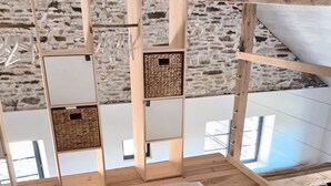 A room with a wooden floor, a patterned rug, and a wooden partition with storage boxes. - Spacious 'Adults Only' loft surrounded by nature (Crespin)