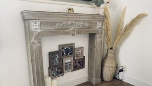 A fireplace with decorative frames and candles. - Air-conditioned studio with parking and close to the sea. (Carqueiranne)