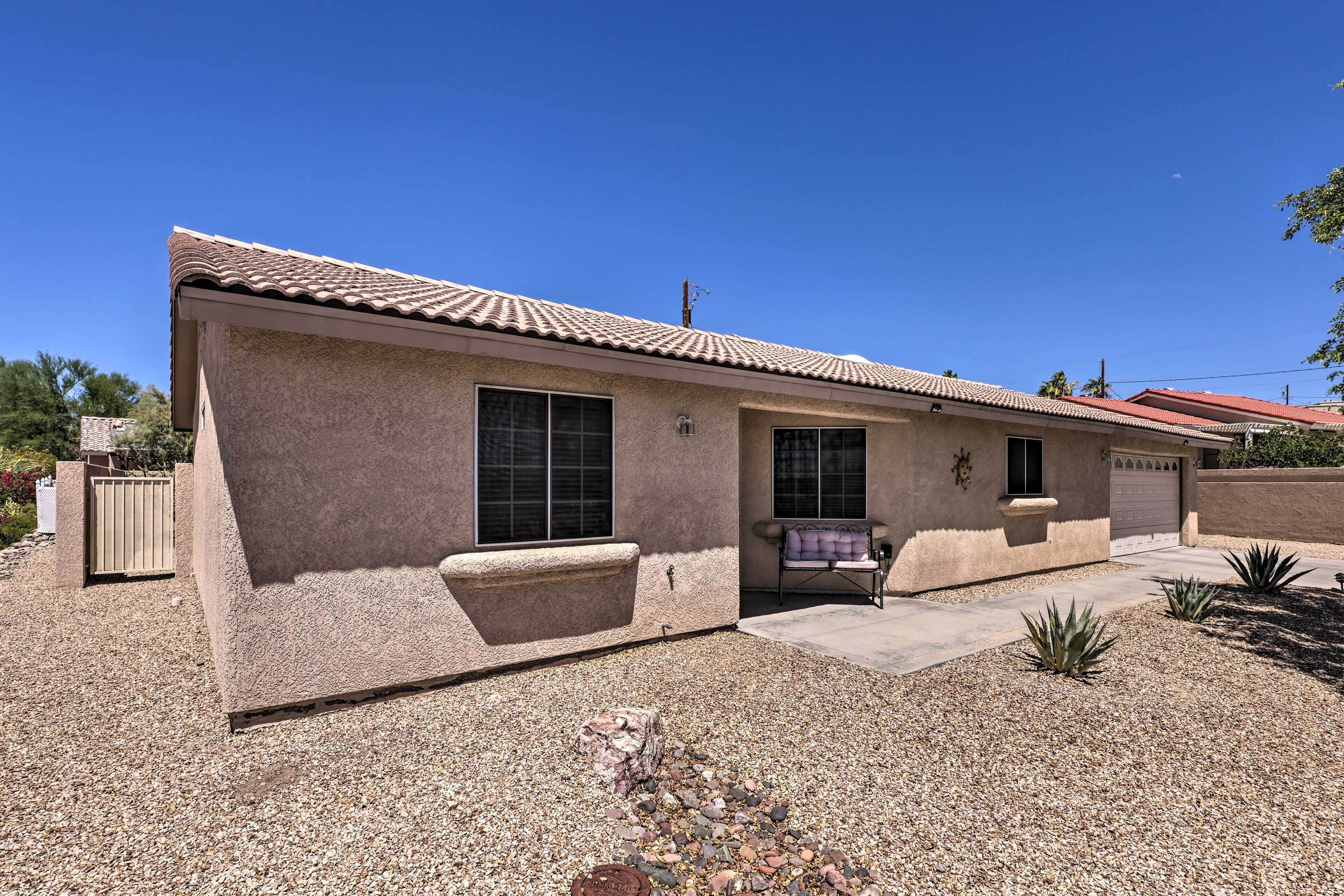 A single-story house with a tiled roof, a front porch, and a small patio area.