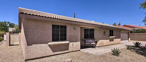 A single-story house with a tiled roof, a front porch, and a small patio area.