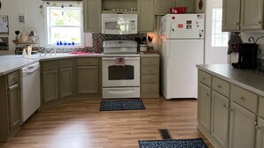 A kitchen with wooden cabinets, a microwave, a stove, and a refrigerator.