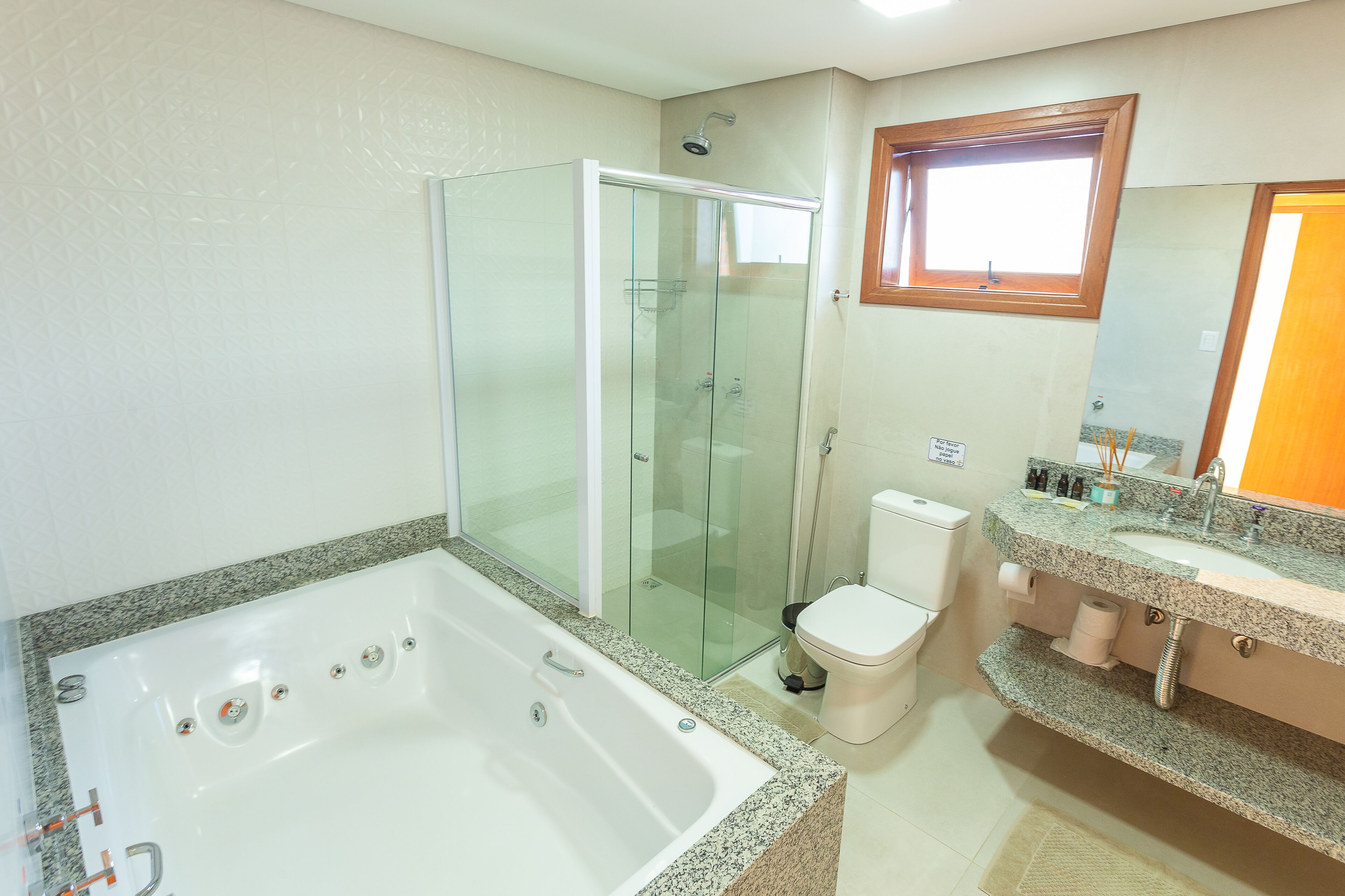Ein Badezimmer mit Duschkabine, Badewanne, Toilette und Waschbecken mit Waschtisch.