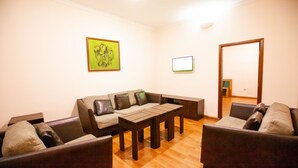A living room with a sofa, two armchairs, a coffee table, and a painting on the wall. - GENESIS COTTAGE (Port Harcourt)