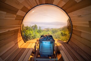 A circular wooden structure with a view of a landscape through a large window. - Bela Vista 5 (Bregi)