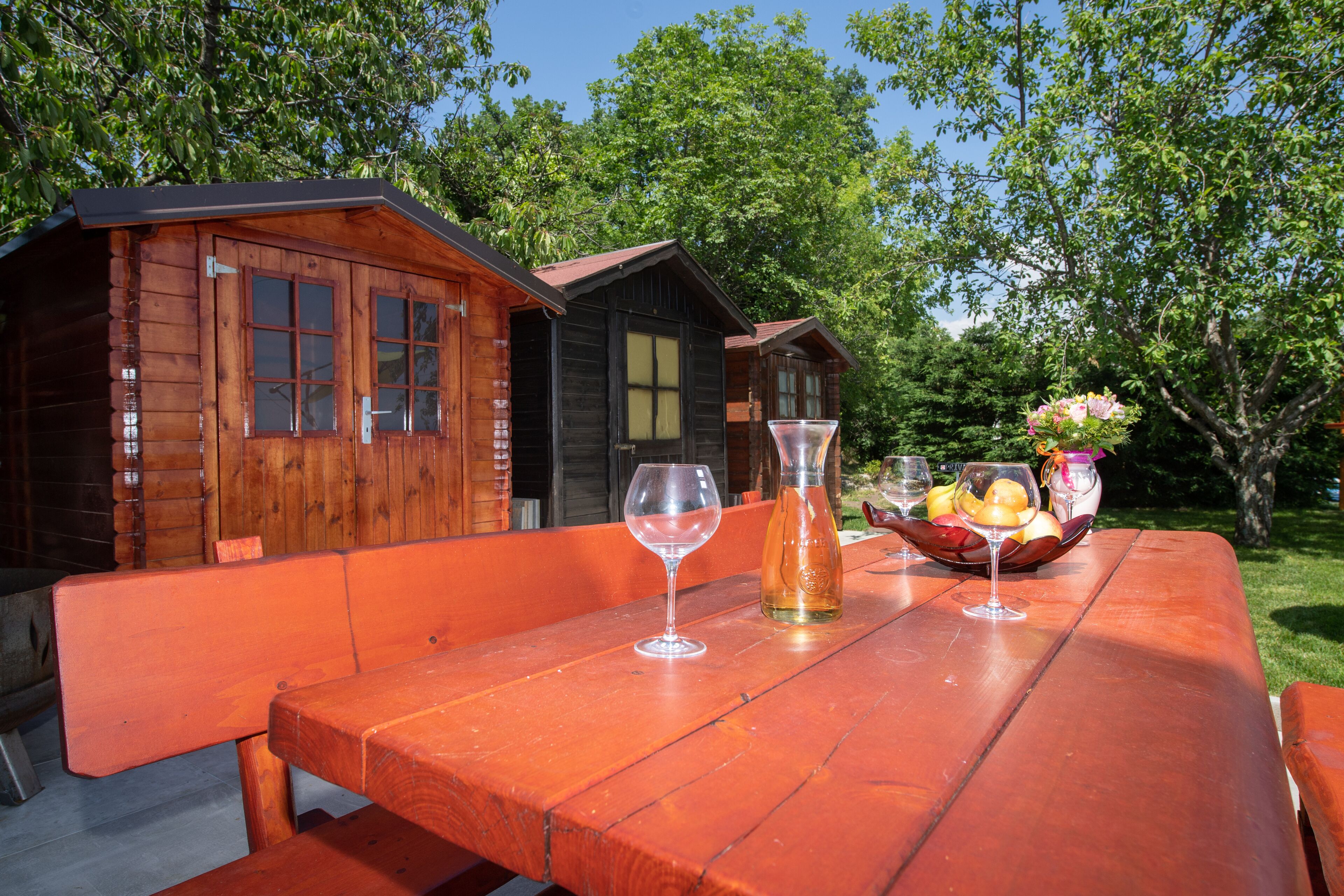 A wooden cabin with a picnic table set up outdoors.