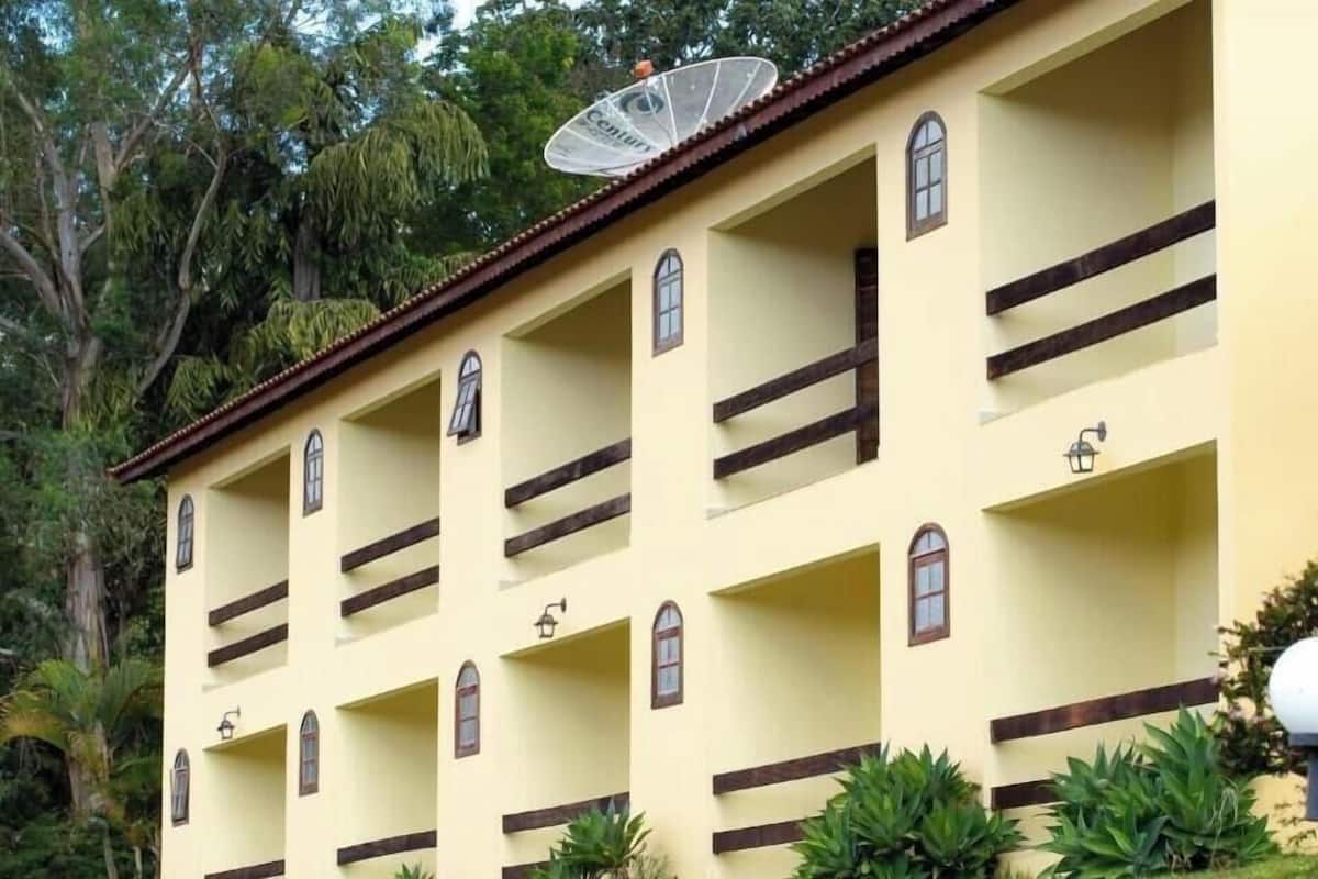 Een meerhoog gebouw met balkons en een schotelantenne, evenals een schotelantenne op het dak.