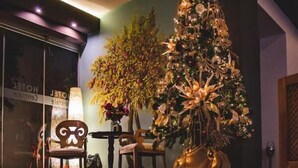 A lobby with a reflective floor, a Christmas tree, and a large vase with flowers. - Platamon Centrale (Dio-Olympos)