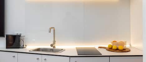 A compact kitchen with a Bosch microwave, a sink, and a small countertop with lemons.