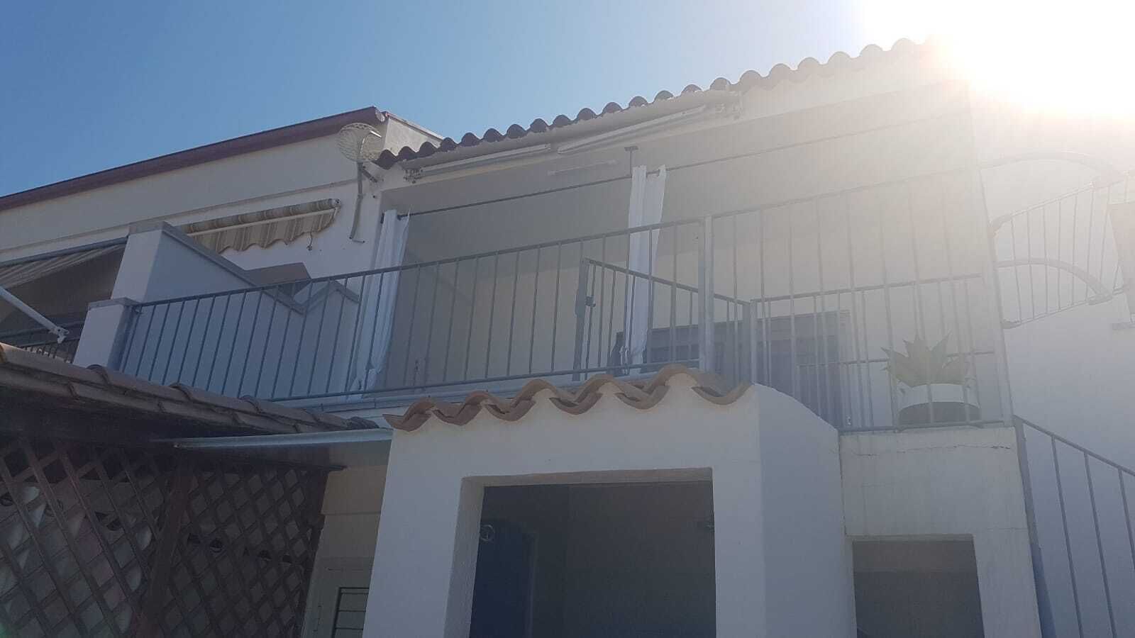 Un edificio de dos pisos con un balcón y una ventana pequeña.