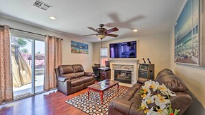 Una sala de estar con sofá, sillón, mesa de centro y chimenea.