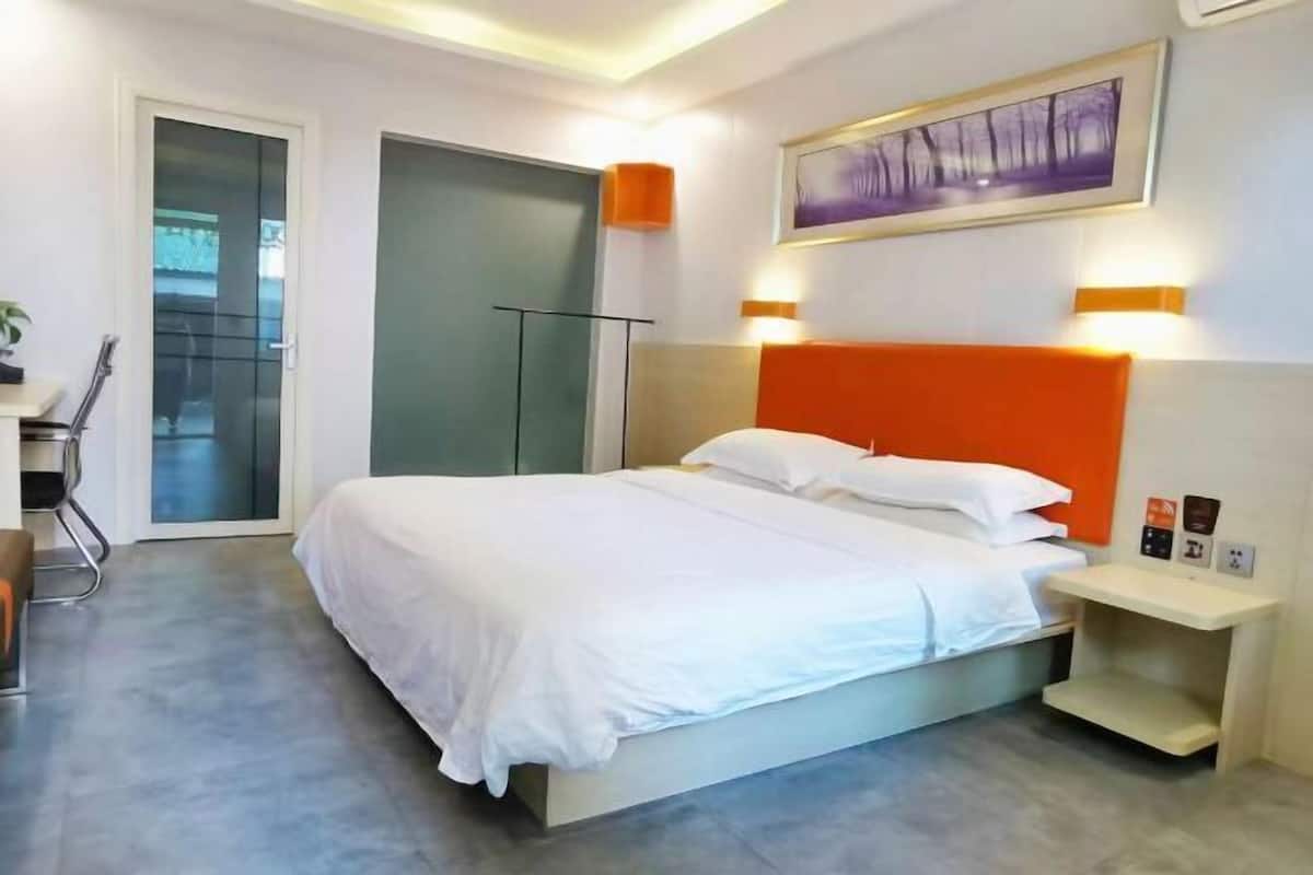Une chambre d’hôtel moderne, dotée d’un grand lit, d’un bureau et d’une chaise.