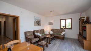 A living room with a sofa set, a dining table with chairs, a coffee table, and a TV stand. - Bela Vista 4 (Bregi)