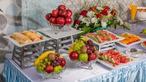 Een buffet met verschillende soorten fruit en een bloemstuk.