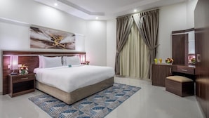Een moderne hotelkamer met een groot bed, een nachtkastje, een dressoir en een spiegel.