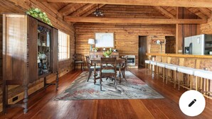 A rustic wooden interior with a dining area, bar, and kitchen. -  Cabin By the Bay A unique authentic log cabin by the beach with fenced yard (Panacea)