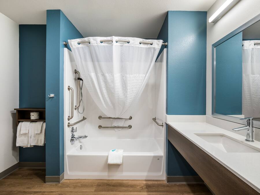 A modern bathroom with a bathtub, shower, and sink.