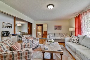 A living room with a coffee bar, two sofas, a coffee table, and a staircase leading to another level.