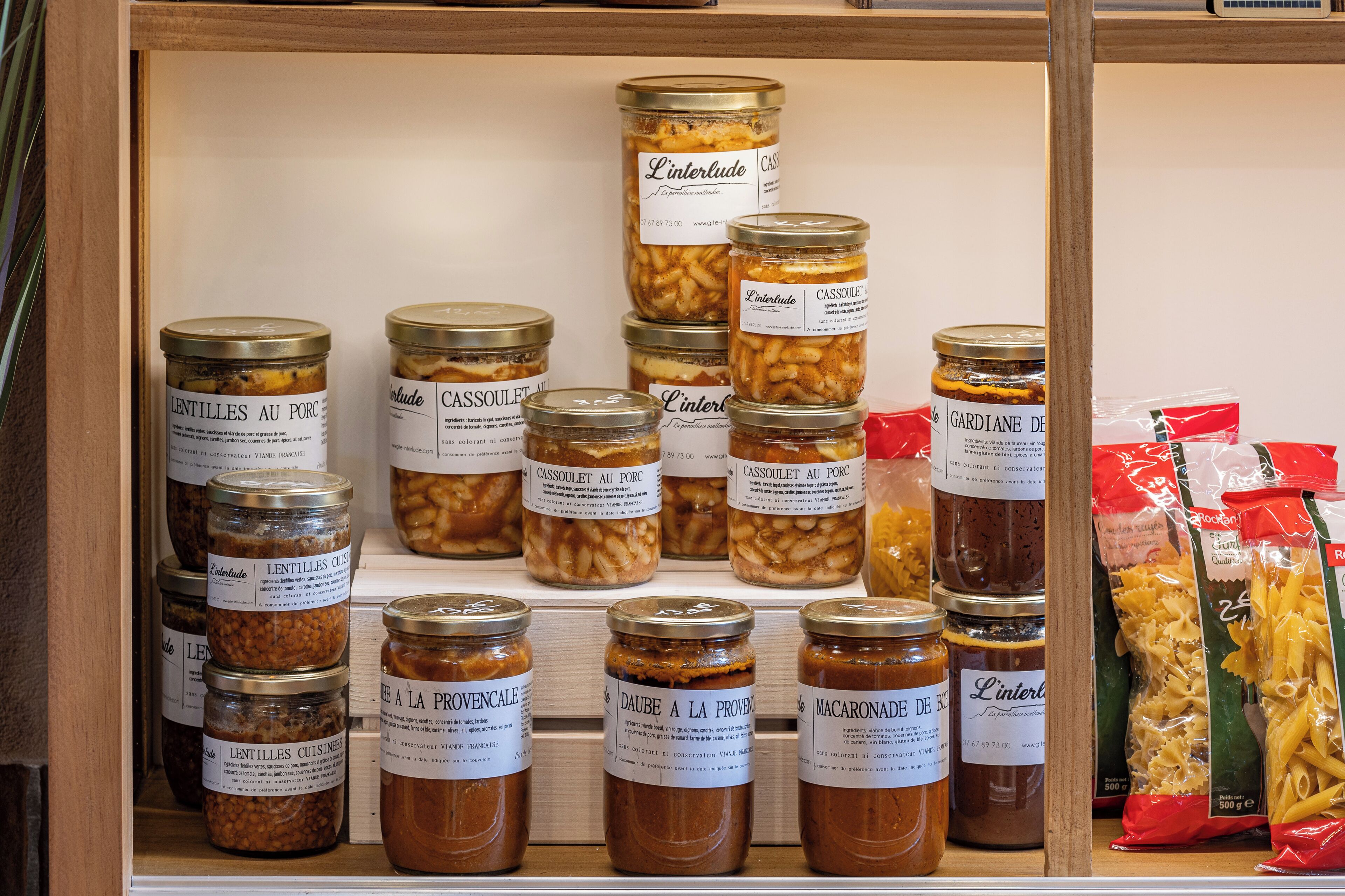 A display of various food items, including jars of preserved foods and pasta packages.