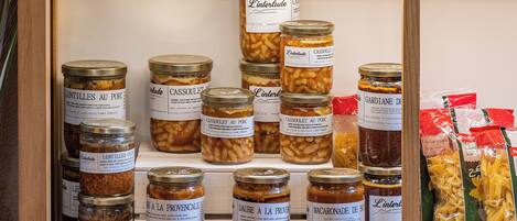 A display of various food items, including jars of preserved foods and pasta packages.