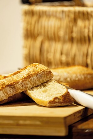 Slices of toasted bread on a wooden cutting board with a knife.