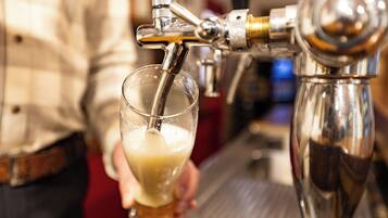A tap dispensing beer into a glass held by a person.