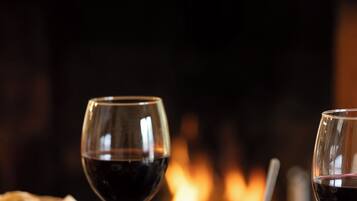 A table with a glass of red wine, a jar of spread, and bread.