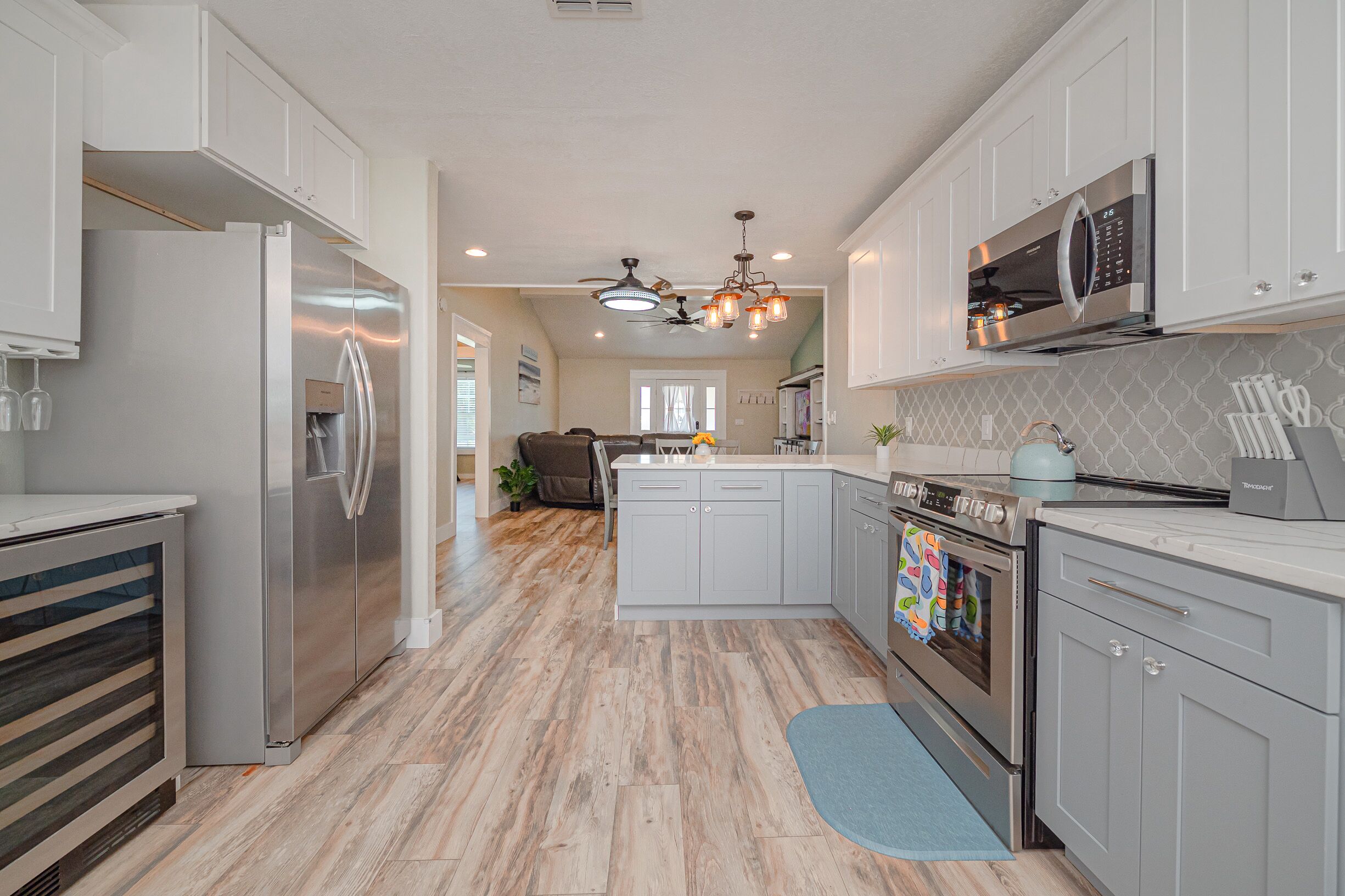 A modern kitchen with stainless steel appliances, white cabinetry, and a central island.