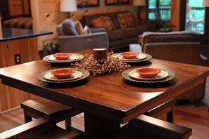 A dining table set with plates and a centerpiece, surrounded by chairs.