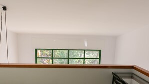 Une pièce avec une fenêtre donnant sur un beau paysage, un plafond en bois et une table en verre.