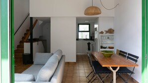 Un intérieur moderne avec un canapé, une table à manger et un escalier.