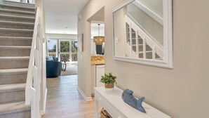A modern interior with a staircase, a dining area, and a view of the outdoors. - Newly Remodeled Bathrooms - 8D Mariners Walk - Ocean Views - Wild Dunes (Isle Of Palms)