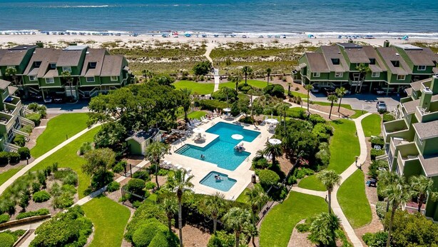 A resort with a central pool, beachfront view, and multiple green-roofed buildings. - Newly Remodeled Bathrooms - 8D Mariners Walk - Ocean Views - Wild Dunes (Isle Of Palms)