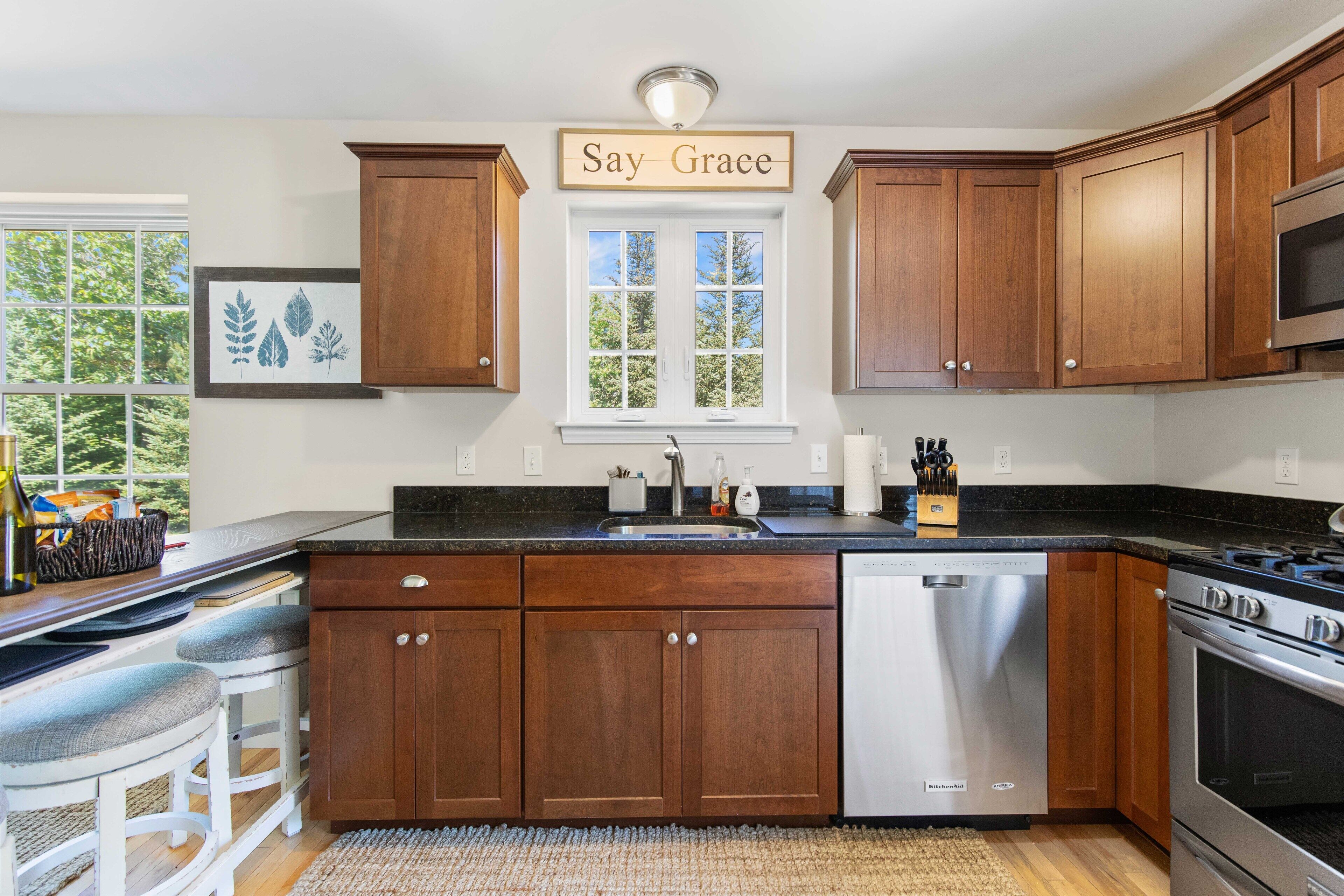 A kitchen with wooden cabinets, a stainless steel dishwasher, and a gas stove.