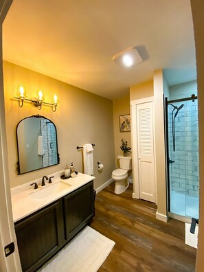 Une salle de bain avec un lavabo, un miroir et des toilettes.