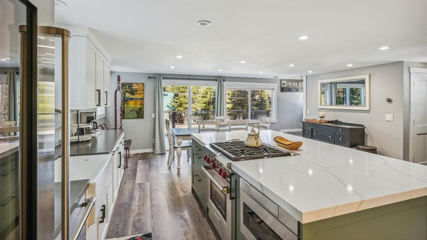 A modern kitchen with a large island, built-in ovens, and a view to the outdoors.