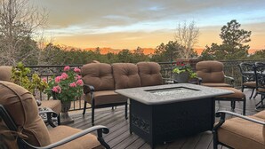 Terraza con asientos acolchados, una chimenea y vistas a las montañas.
