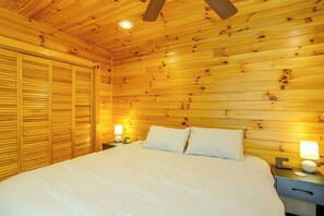 A wooden room with a bed, nightstands, and a ceiling fan. - Cozy Boone Cabin w/ Deck: Close to Downtown! (Boone)