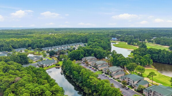 Un barrio residencial con casas, un río y un campo de golf.