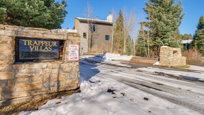 A stone wall with a sign reading "Trappeur Villas" and a parking permit sign. - Walk to Ski Lift: Breckenridge Retreat w/ 2 Decks! (Breckenridge)