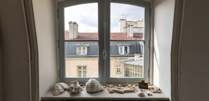 A window with a view of buildings and a collection of seashells on the sill. - ON THE BANKS OF SEINE-AN EXPLICIT 17TH CENT.TOWNHOUSE LE MARAIS VILLAGE ST PAUL (Paris)