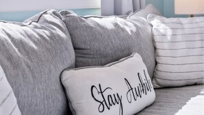 A bedroom with a view of sailboats, a window with curtains, and a pillow with 'Stay Awake' text. - Luxury 2-Story PTown Condo: 5 Min Walk to Commercial St. Private Patio & Parking (Provincetown)