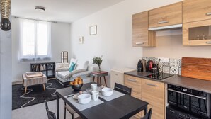 Eine moderne Küche mit Holzschränken, einer schwarzen Arbeitsplatte und einem eingebauten Ofen.