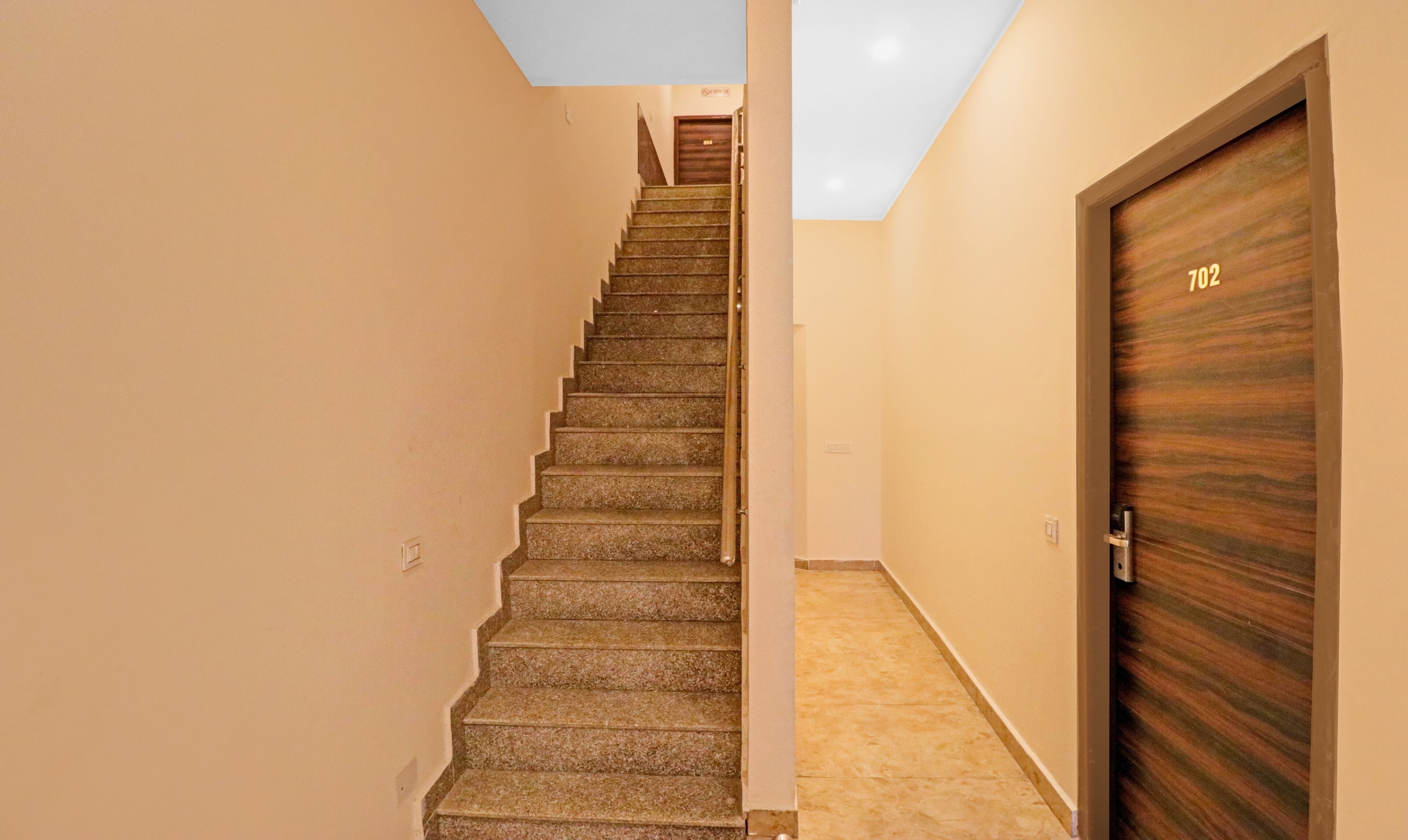 A staircase leading to a door with the number 702.