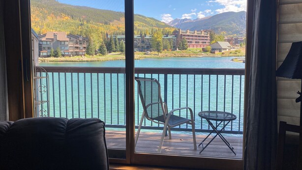 A balcony with a view of a lake, mountains, and buildings. - Lakeside, Ski Condo with Amazing Views, Quiet, Family-Friendly (Keystone (Dillon))