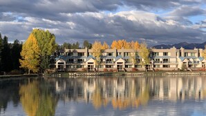 A lakeside hotel with multiple buildings, a calm lake reflecting the structures, and autumn-colored trees. - Lakeside, Ski Condo with Amazing Views, Quiet, Family-Friendly (Keystone (Dillon))