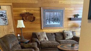 A cozy living room with a brown leather sofa, a recliner, a patterned rug, and a framed picture on the wall. - Lakeside, Ski Condo with Amazing Views, Quiet, Family-Friendly (Keystone (Dillon))