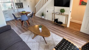 A modern living room with a sofa, coffee table, and dining area.